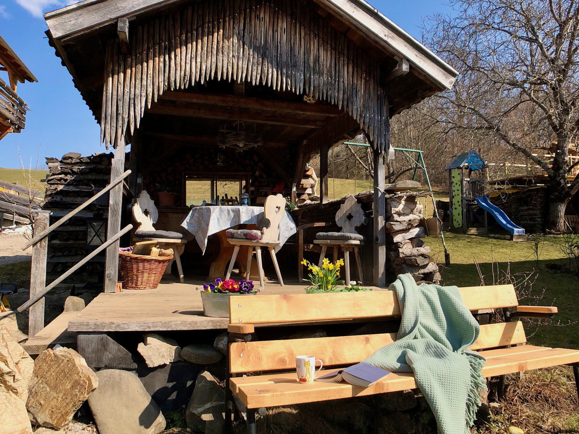Gemütliche Grillhütte im Garten mit Spielplatz im Hintergrund